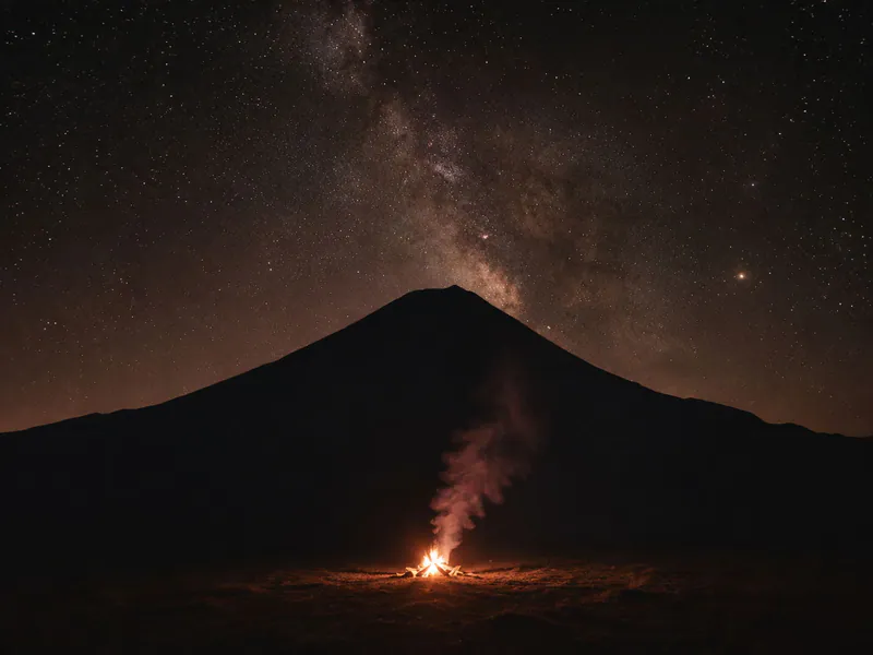 Small campfire on a mountain plateau at night.
